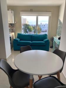 sala de estar con mesa blanca y sofá azul en J-H- DEPARTAMENTO, en Monte Hermoso