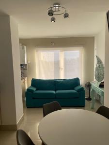 sala de estar con sofá azul y mesa en J-H- DEPARTAMENTO en Monte Hermoso