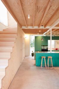 uma cozinha com um balcão verde e dois bancos em EvaMaria em Varsenare