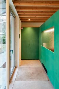 un couloir vide avec des murs verts et une porte dans l'établissement EvaMaria, à Varsenare