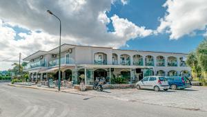 a large building with cars parked in front of it at Porto Marina Aparthotel in Gouvia