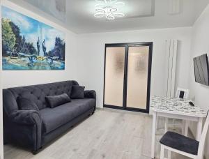a living room with a couch and a table at Blue Apartament Braila in Brăila +10 photos