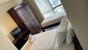a small room with two beds and a window at RESORT SUITES AT BARJAYA TIMES SQUARE kL in Kuala Lumpur
