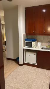 a kitchen with a sink and a microwave at RESORT SUITES AT BARJAYA TIMES SQUARE kL in Kuala Lumpur