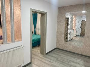 a hallway with a mirror and a bed in a room at D&D New Residence in Piteşti