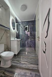 a bathroom with a toilet and a sink at Blue Apartament Braila in Brăila