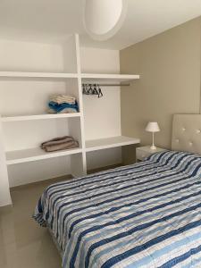 1 dormitorio con 1 cama con estanterías blancas en J-H- DEPARTAMENTO en Monte Hermoso