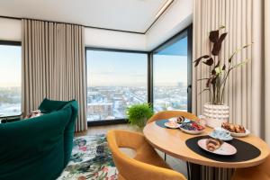 uma sala de estar com uma mesa com comida em Luxury sea view studio apartment in a skyscraper! em Taline