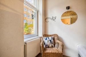 silla de mimbre en una habitación con ventana en Historical Wine Apartment en Bratislava