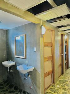 a bathroom with two sinks and a window at The Continental Hostel El Nido in El Nido