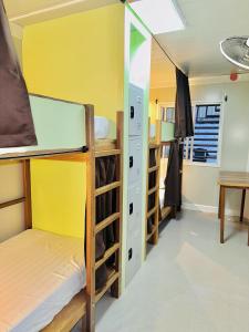 a room with three bunk beds and a table at The Continental Hostel El Nido in El Nido