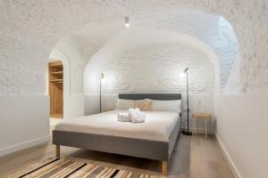 um quarto com uma cama numa parede de tijolos brancos em Modern and Bright- 2 Bd 2 Bth - Center em Madri