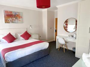 Habitación de hotel con cama y escritorio en Legends Hotel, en Brighton & Hove