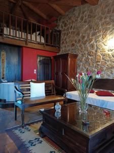 - un salon avec un canapé et une table fleurie dans l'établissement Ξενώνας Λίκνο, à Synikia Mesi Trikalon