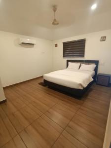 um quarto com uma cama e piso em madeira em sahara suites em Cochin