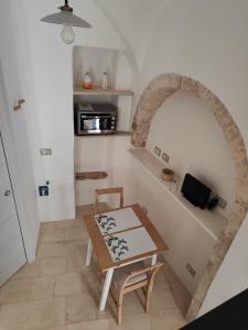 a room with a table and a kitchen with an archway at Archi Antichi in Putignano