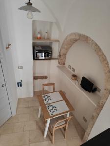 プティニャーノにあるArchi Antichiのテーブル付きの部屋、アーチ道付きのキッチンが備わる客室です。