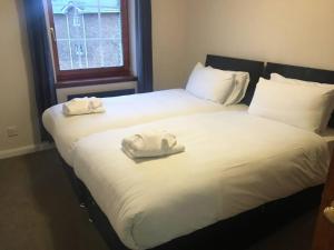 2 camas con toallas blancas encima en My Waterfront Apartment, views over Water of Leith, en Edimburgo