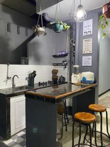 eine Küche mit einer Theke und 2 Hockern in der Unterkunft Rumahtata Homestay in Purwokerto
