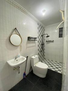 ein Badezimmer mit Toilette und Waschbecken in der Unterkunft Rumahtata Homestay in Purwokerto