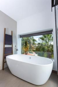 Una gran bañera blanca en un baño con ventana. en Casa Sãnti - Luxury Home- For 8 guests, en Benissa