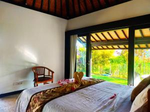 a bedroom with a bed and a large window at 3BRBeautifull Villa Queen With Stunning Rice Field in Saba