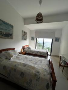 a bedroom with two beds and a window at Charming Zen-style Beach apartment at Punta Caelo in San Carlos