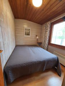 索特的住宿－Rantamökki 28，木制客房内的一间卧室,配有一张床