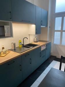 a kitchen with blue cabinets and a sink at Maros Apartman in Budapest