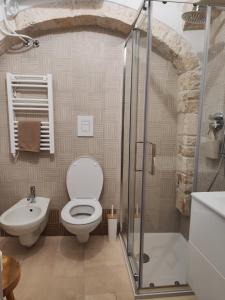 y baño con aseo, lavabo y ducha. en Archi Antichi, en Putignano