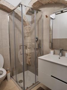 y baño con ducha, aseo y lavamanos. en Archi Antichi, en Putignano