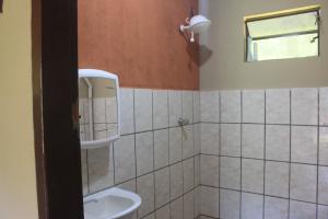 a bathroom with a toilet and a sink at Refúgio Leve Amor in Águas de Lindóia
