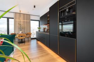 a kitchen with black cabinets and a dining room at Luxury sea view studio apartment in a skyscraper! in Tallinn