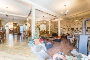 a large living room with a fireplace and tables and chairs at Hotel Old Seti in Mestia