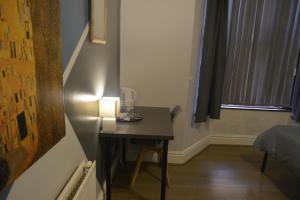 a room with a small table with a lamp on it at Kensington Guest House Liverpool in Liverpool +22 photos