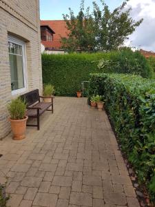 un patio avec un banc et quelques plantes dans l'établissement Haus Sonne _ Meer, à Sierksdorf