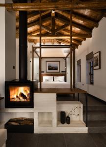 - un salon avec une cheminée et un lit dans l'établissement Unedo All Seasons Hotel, à Palaios Panteleimonas