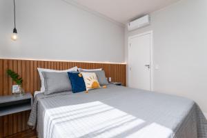 een slaapkamer met een groot bed met blauwe kussens bij Arpoador Design - Quadra da Praia e WIFI 500Mb in Rio de Janeiro