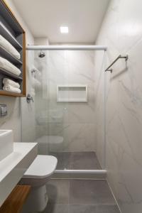 een badkamer met een glazen douche en een toilet bij Arpoador Design - Quadra da Praia e WIFI 500Mb in Rio de Janeiro
