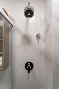 een douche met een douchekop in de badkamer bij Arpoador Design - Quadra da Praia e WIFI 500Mb in Rio de Janeiro