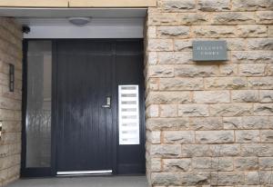 哈羅蓋特的住宿－Harrogate Self Catering - Regent's Court Azure Suite，砖墙上标有标志的黑色门