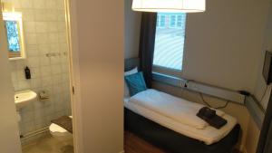 a small room with a small bed in a bathroom at Hotel Charlotte / Stella in Uppsala