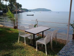 a table and chairs with a view of the water at GS Home Sea View Delux Room in Vagator