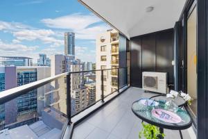 a balcony with a table and a view of a city at Stylish apartment in Parramatta in Sydney