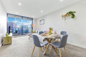 シドニーにあるStylish apartment in Parramattaのリビングルーム(テーブル、椅子、ソファ付)