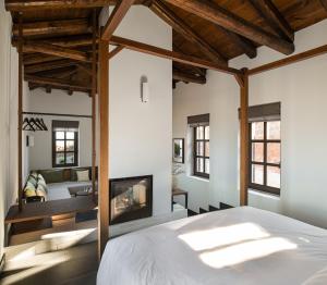 1 dormitorio con 1 cama y chimenea en Unedo All Seasons Hotel, en Palaios Panteleimon