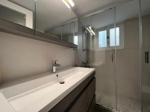 a white bathroom with a sink and a shower at VoulaCnSand in Athens