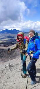 two people standing on the top of a mountain at Cuscungo Cotopaxi Hostel & Lodge in Chasqui