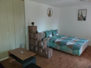 een slaapkamer met een bed en een houten tafel bij Joli petit appartement in Charleville-Mézières