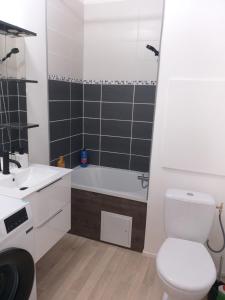 een badkamer met een bad, een toilet en een wastafel bij Joli petit appartement in Charleville-Mézières